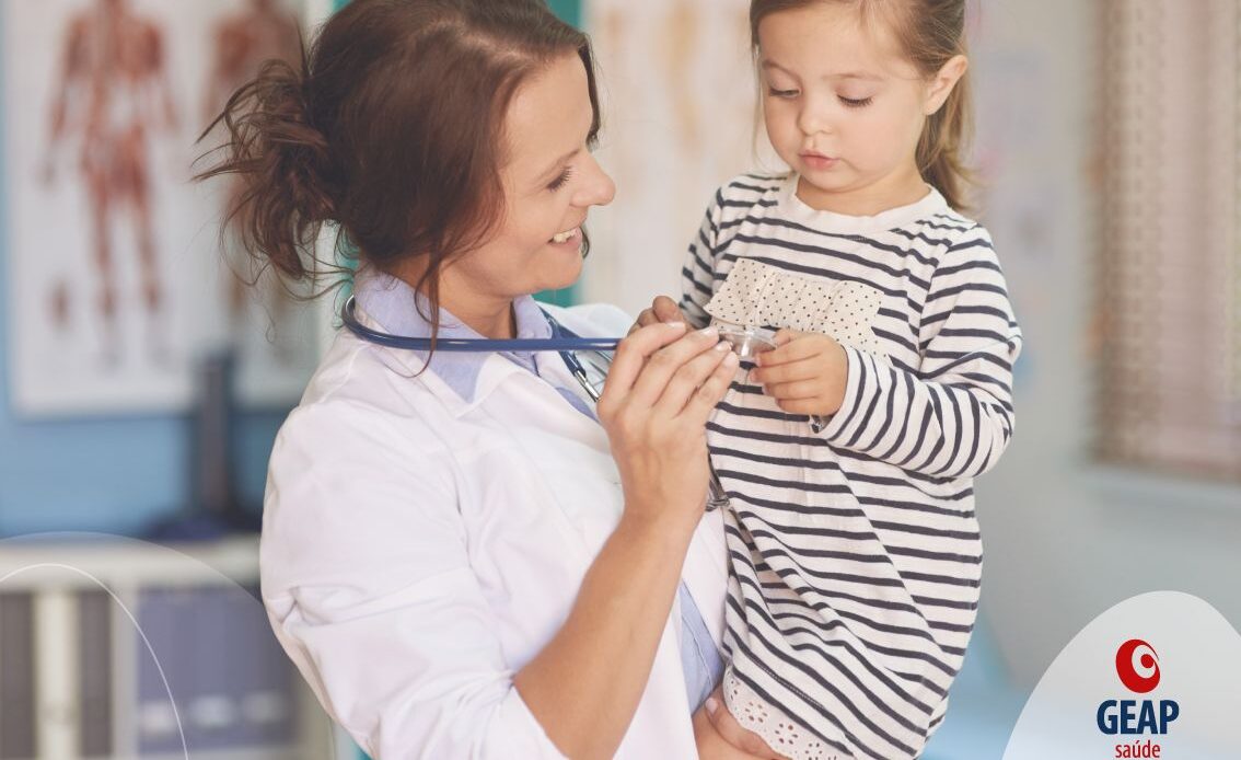 Pediatra segurando criança no colo