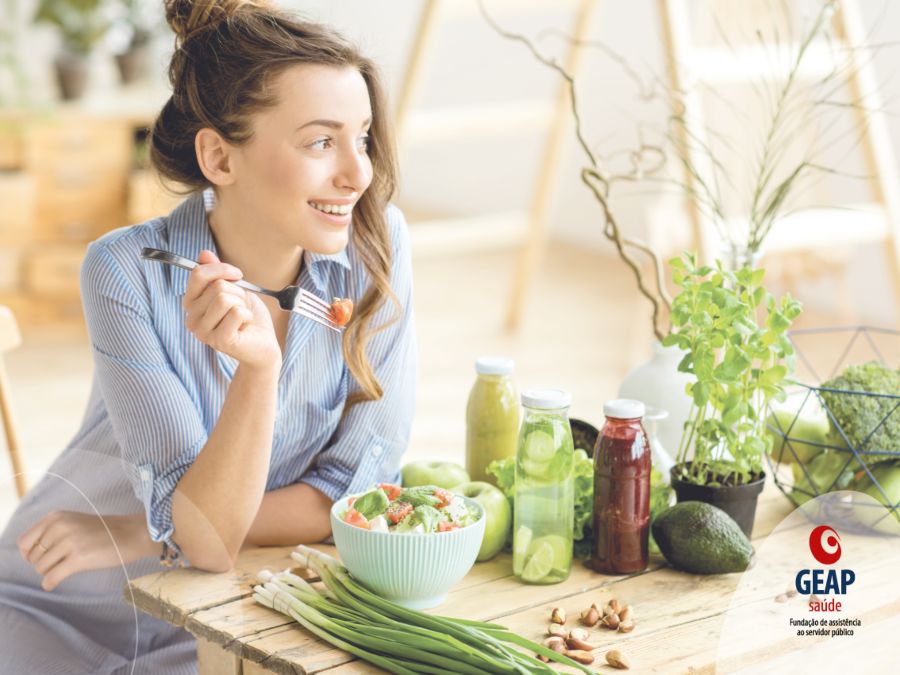 Mulher sorridente comendo salada